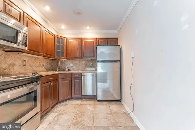 a kitchen with stainless steel appliances granite countertop a refrigerator and a stove top oven