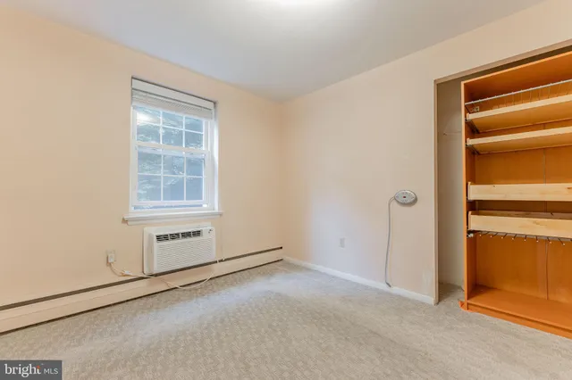 a view of an empty room and kitchen