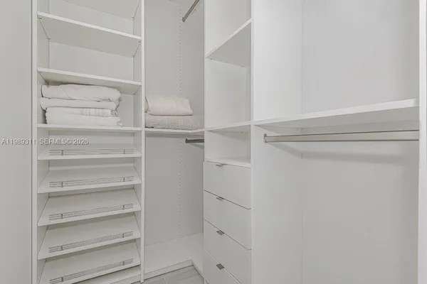 a view of walk in closet with empty racks