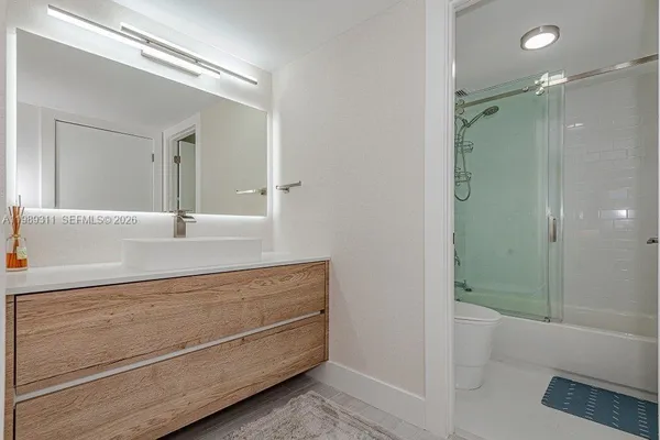 a bathroom with a shower sink and mirror