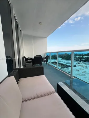 a living room with furniture and a floor to ceiling window