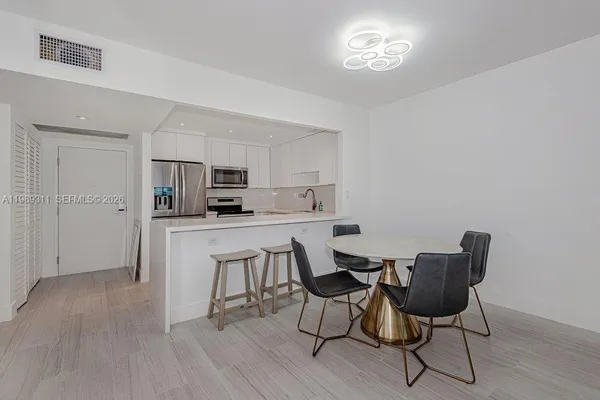 a kitchen with stainless steel appliances granite countertop a stove top oven a sink dishwasher and white cabinets with wooden floor