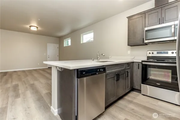 a kitchen with stainless steel appliances a stove a sink and a microwave