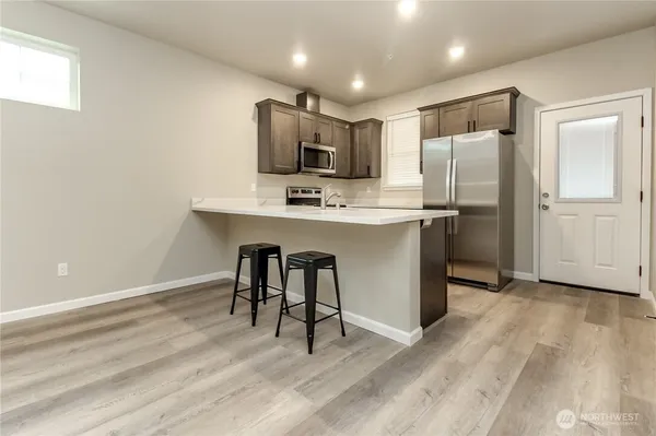a kitchen with stainless steel appliances a sink cabinets and wooden floor