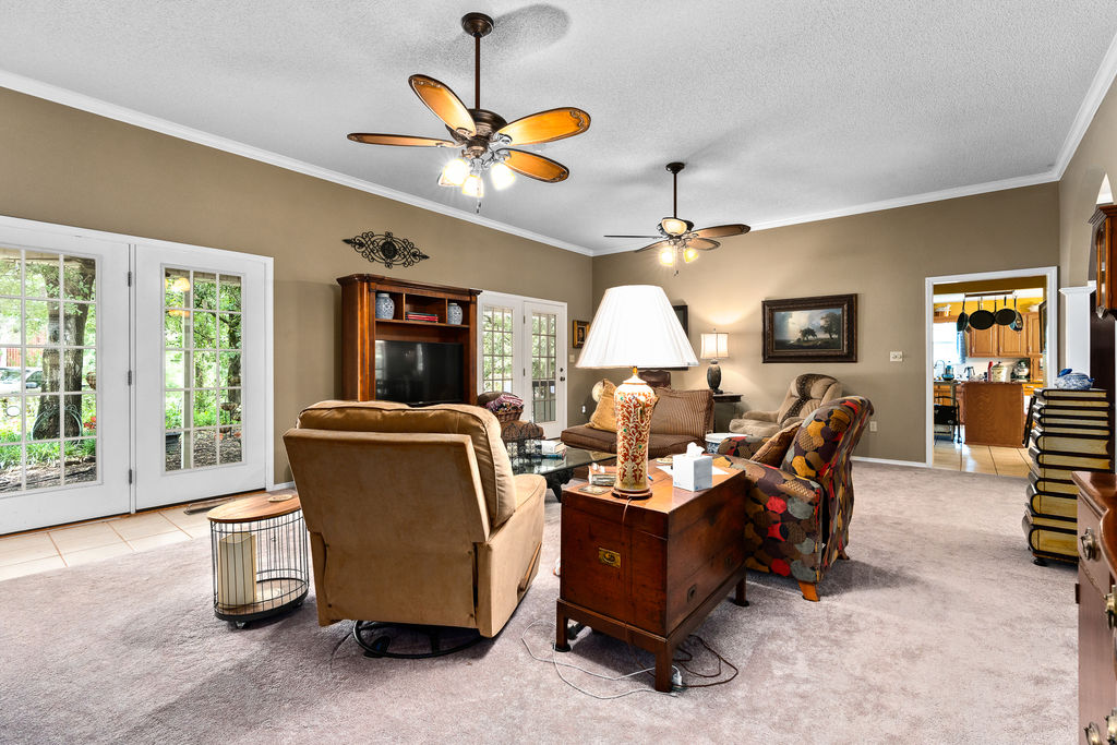 365 Calihan Road Booneville, AR 72927 - Photo 33 of 59 Spacious living area featuring neutral-toned walls, crown molding, and two ceiling fans with integrated lighting