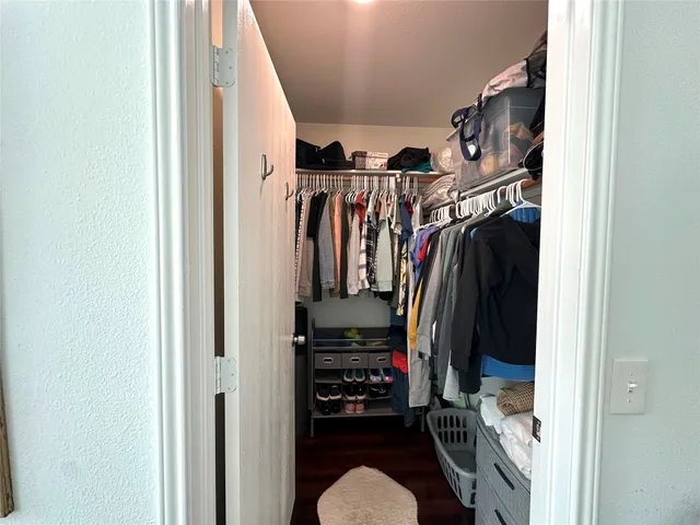 a view of walk in closet with clothes and shoes