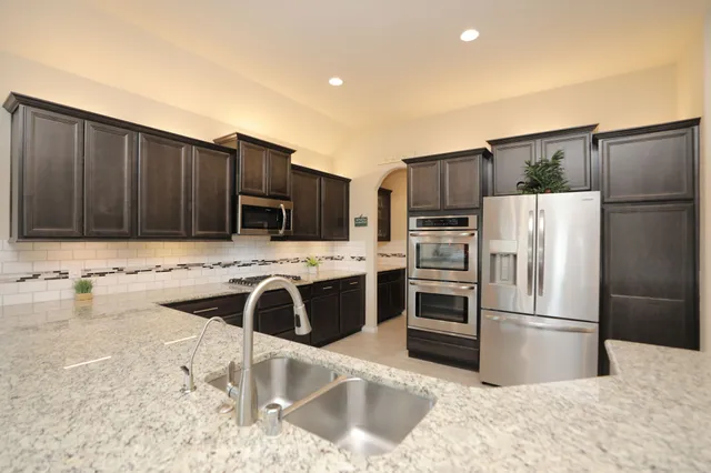 a kitchen with stainless steel appliances granite countertop a stove and a microwave