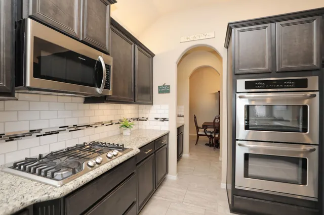 a kitchen with stainless steel appliances granite countertop a sink and refrigerator