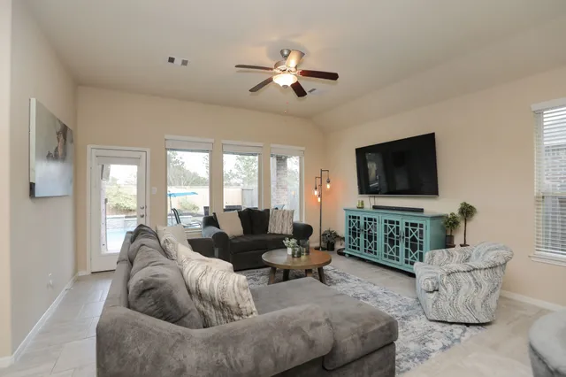 a living room with furniture kitchen view and a chandelier