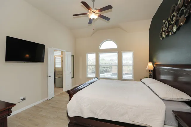 a bathroom with a granite countertop sink a mirror a bathtub and next to a window