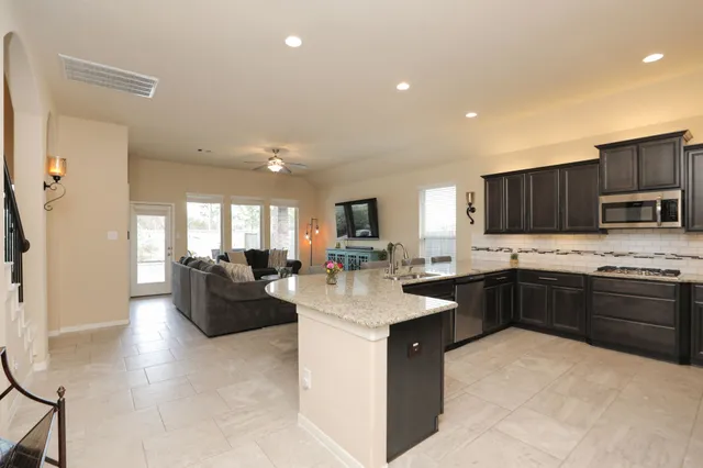 a kitchen with stainless steel appliances kitchen island granite countertop a sink and cabinets