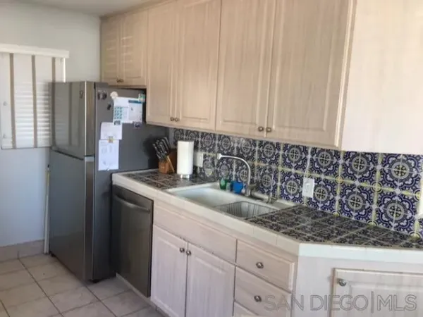 a kitchen with stainless steel appliances granite countertop a refrigerator a sink and white cabinets