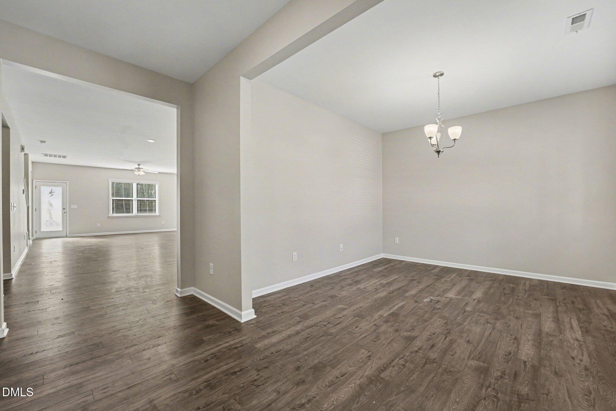 106 Two Daughters Streme Smithfield, NC 27577 - Photo 8 of 25 an empty room with wooden floor and windows
