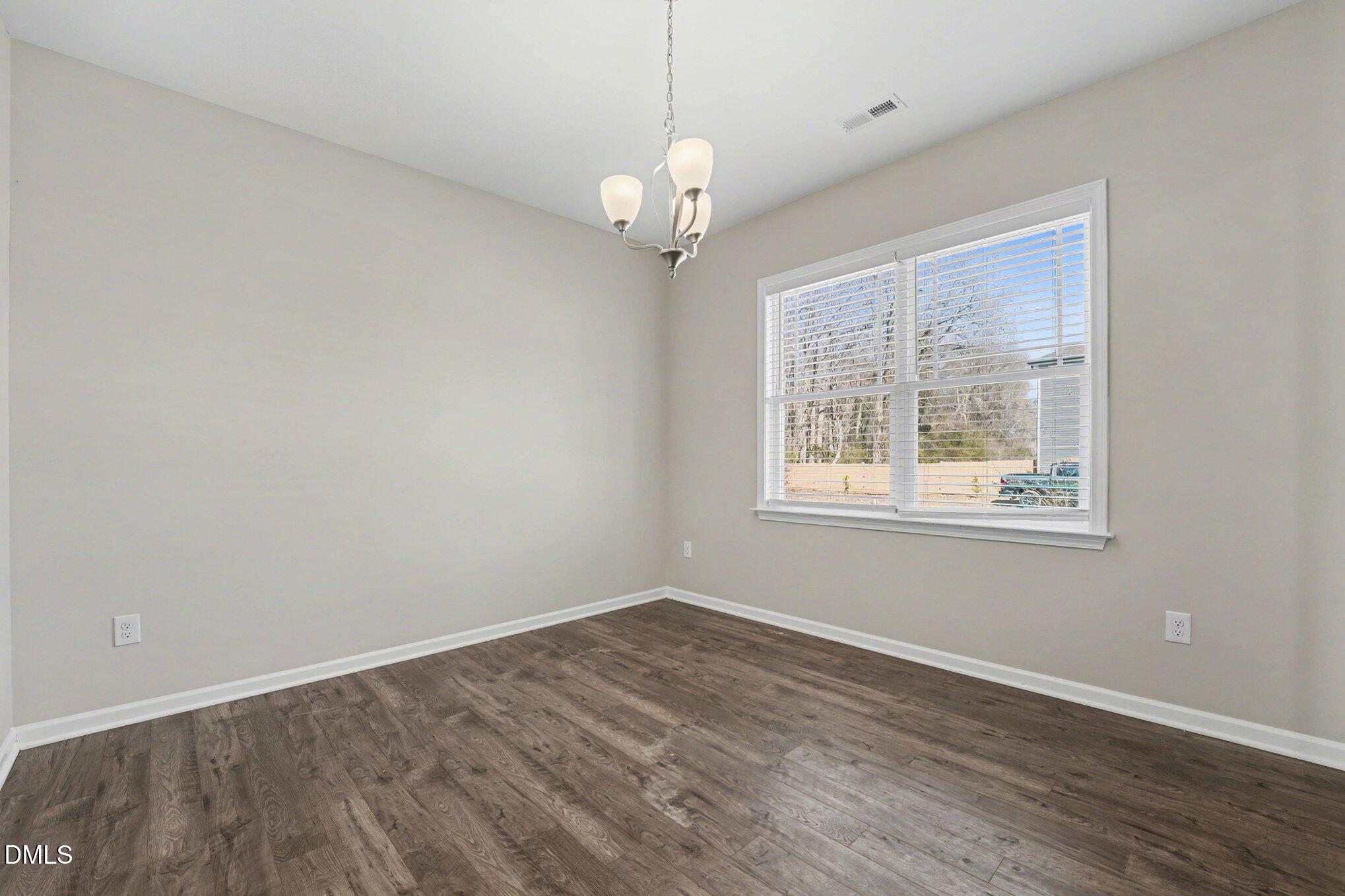 106 Two Daughters Streme Smithfield, NC 27577 - Photo 9 of 25 a view of an empty room with wooden floor and a window
