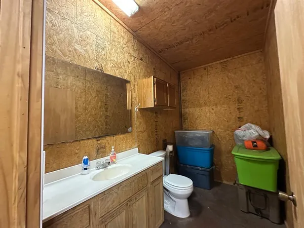 a bathroom with a toilet sink vanity tub and mirror