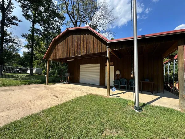 a view of a house with backyard and tree