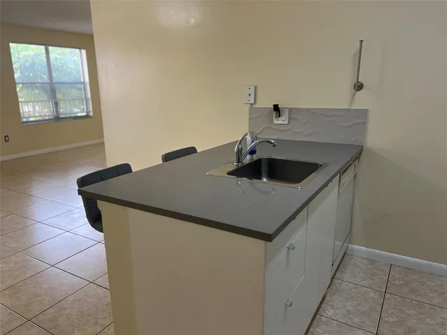 a kitchen with a sink cabinets and window