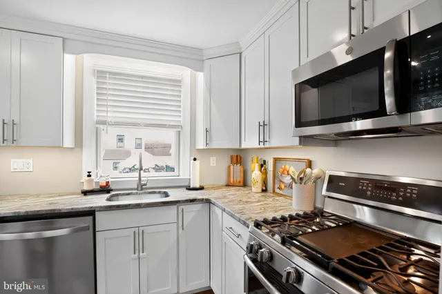 a kitchen with stainless steel appliances a sink a stove and microwave