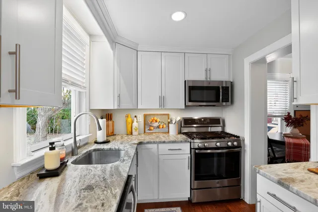 a kitchen with granite countertop a sink and a stove top oven
