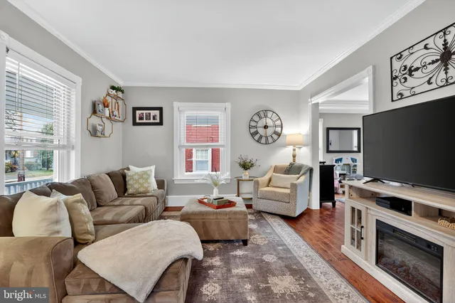 a living room with furniture a flat screen tv and a window