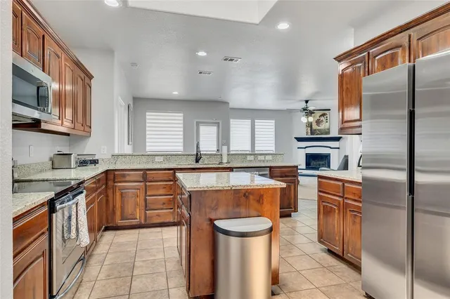 a large kitchen with stainless steel appliances granite countertop a stove a sink dishwasher and a refrigerator