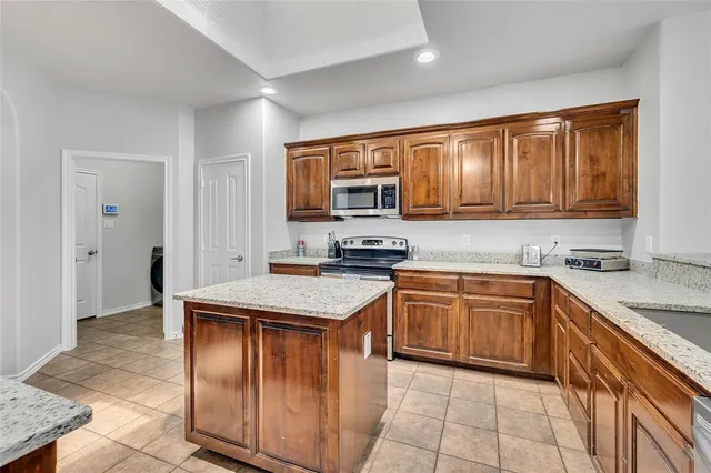 a kitchen with stainless steel appliances granite countertop wooden cabinets a sink and a stove