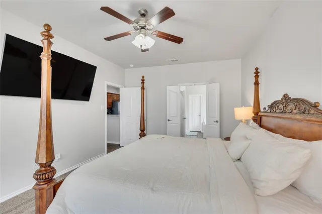 a spacious bedroom with a bed and a flat screen tv