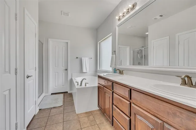 a spacious bathroom with a tub sink and mirror