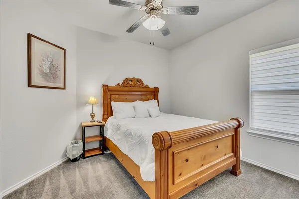 a bedroom with a bed and a ceiling fan