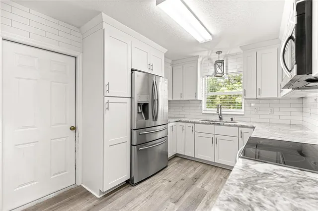 a kitchen with white cabinets and white appliances