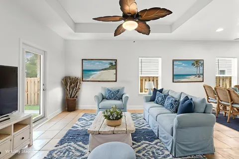 a living room with furniture a flat screen tv and a window