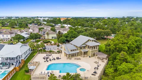 an aerial view of residential houses with outdoor space and trees