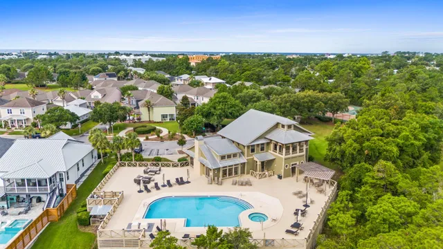 an aerial view of residential houses with outdoor space and trees