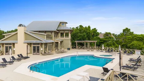 a view of a house with pool and chairs