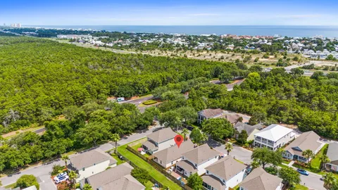 an aerial view of residential houses with outdoor space and ocean view
