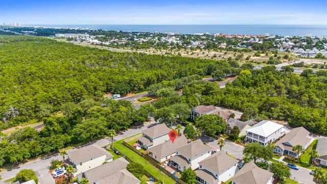 an aerial view of residential houses with outdoor space and ocean view