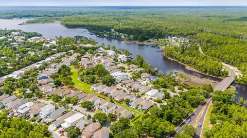 an aerial view of water body with boats and trees all around