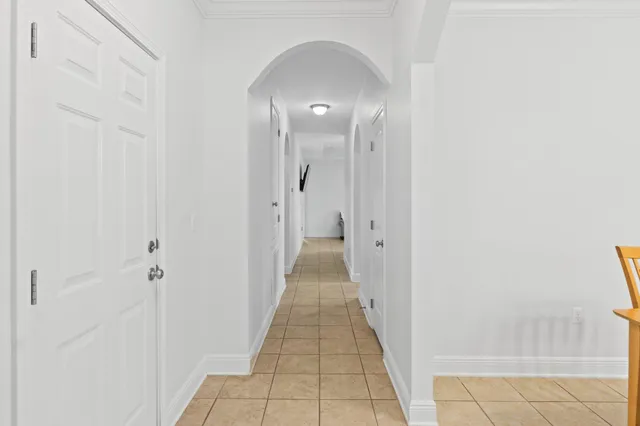 a view of a hallway with wooden floor and a bathroom