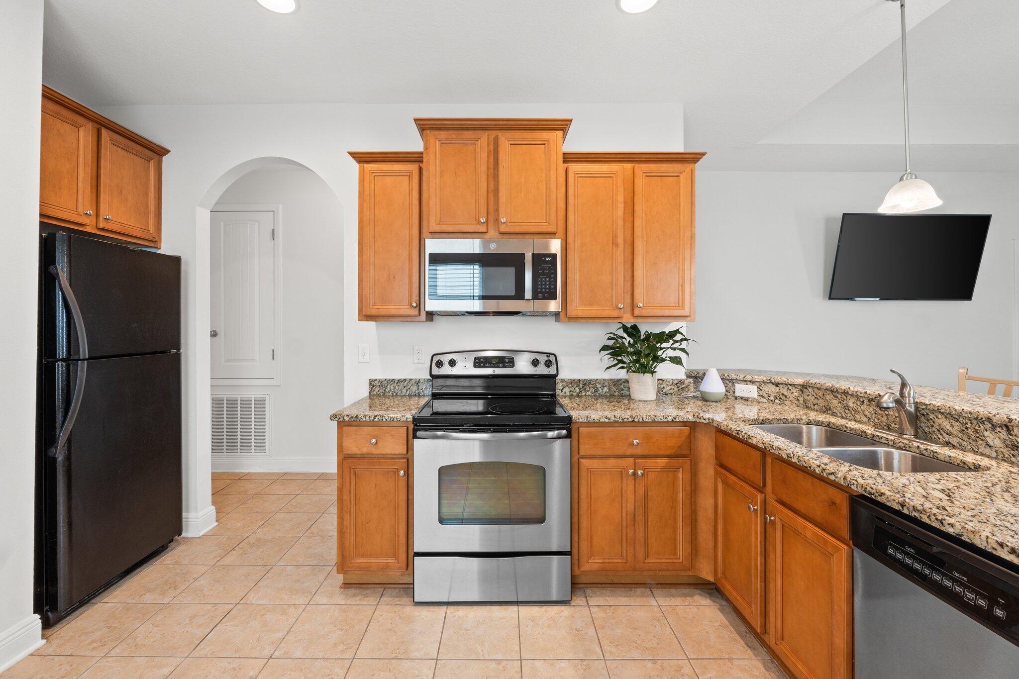 102 Turtle Cove Panama City Beach, FL 32413 - Photo 8 of 42 a kitchen with a stove microwave and refrigerator