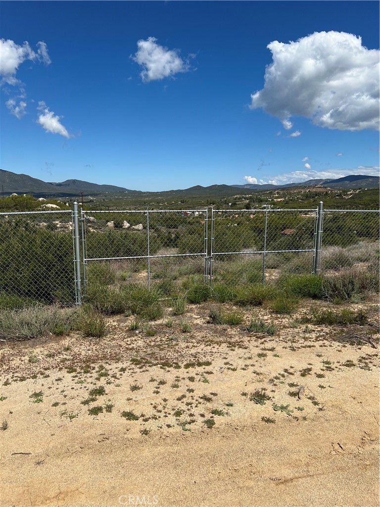 a view of a dry yard with wooden fence