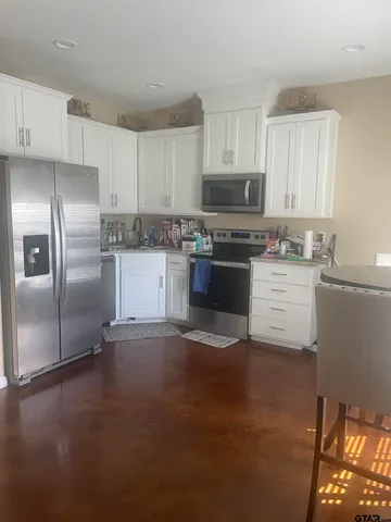 a kitchen with a stove a microwave and chairs