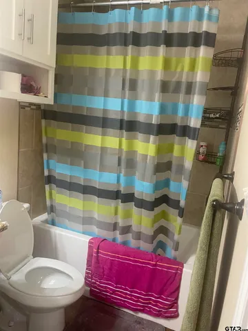 a bathroom with a granite countertop toilet sink and mirror