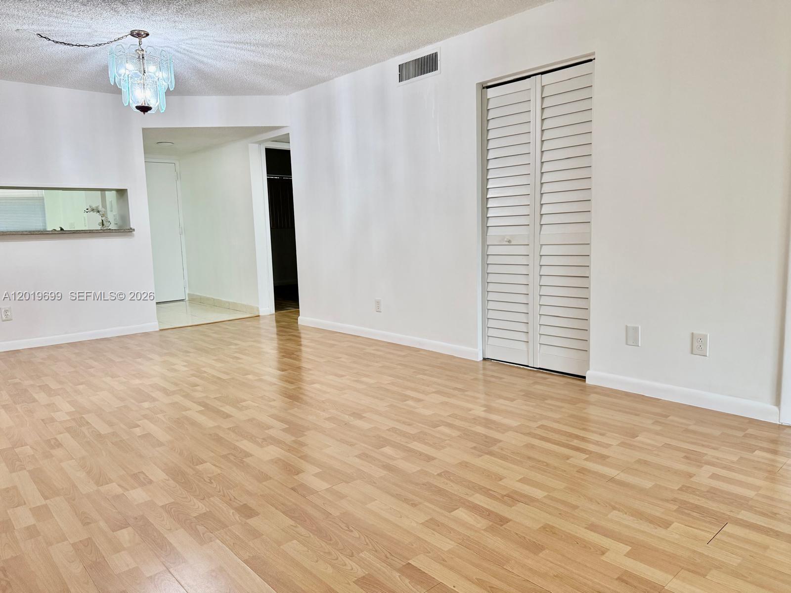 3470 Foxcroft Road, Unit 204 Miramar, FL 33025 - Photo 10 of 40 an empty room with chandelier fan and windows
