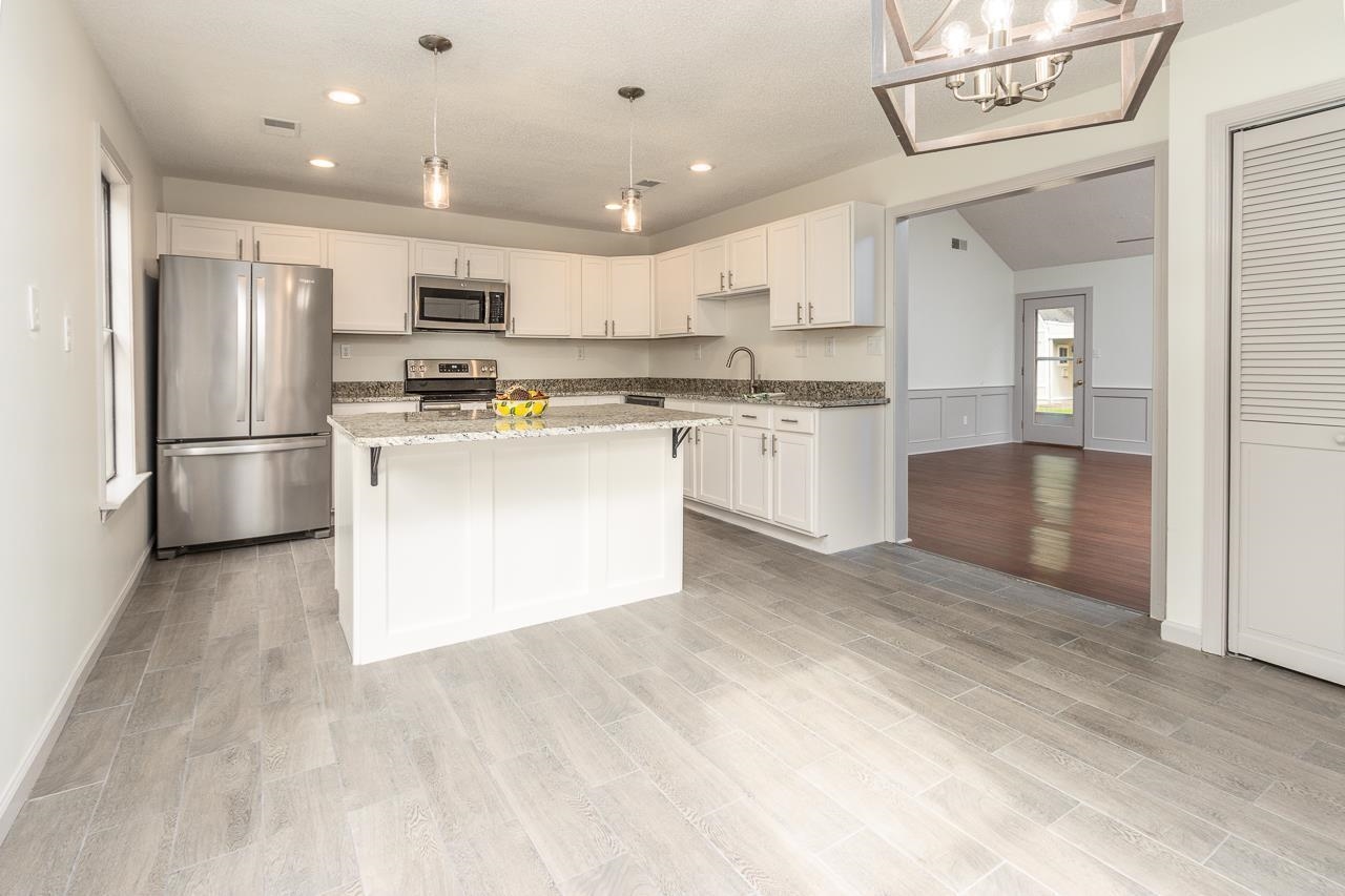 7882 Macon Road Memphis, TN 38018 - Photo 3 of 13 a kitchen with stainless steel appliances granite countertop a refrigerator and a stove top oven