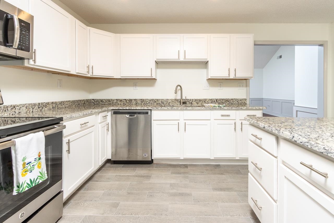7882 Macon Road Memphis, TN 38018 - Photo 6 of 13 a white kitchen with granite countertop stainless steel appliances