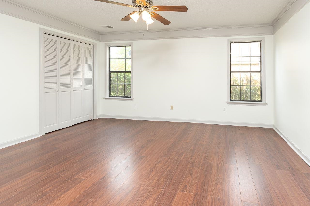 7882 Macon Road Memphis, TN 38018 - Photo 10 of 13 an empty room with wooden floor chandelier fan and windows