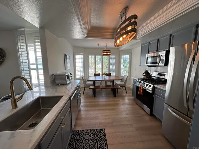 a kitchen with stainless steel appliances granite countertop a sink a stove and a refrigerator