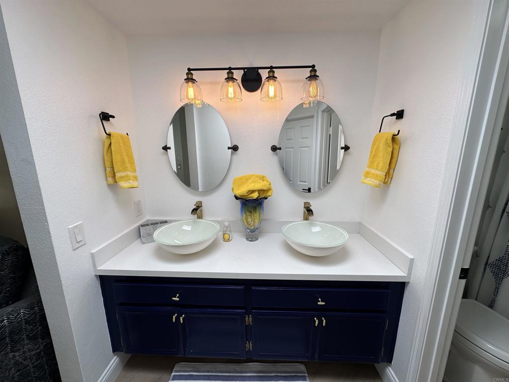 600 The Strand North, Unit 24 Oceanside, CA 92054 - Photo 11 of 19 a bathroom with a sink and a mirror