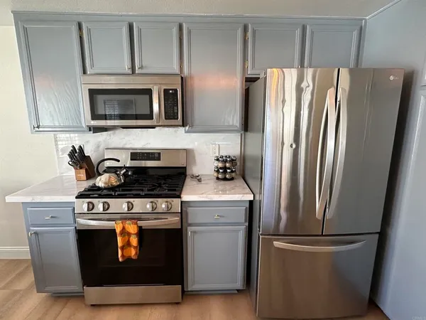 a kitchen with stainless steel appliances wooden cabinets and a wooden floor