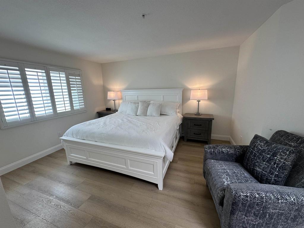 600 The Strand North, Unit 24 Oceanside, CA 92054 - Photo 9 of 19 a spacious bedroom with a bed couch and a larger window